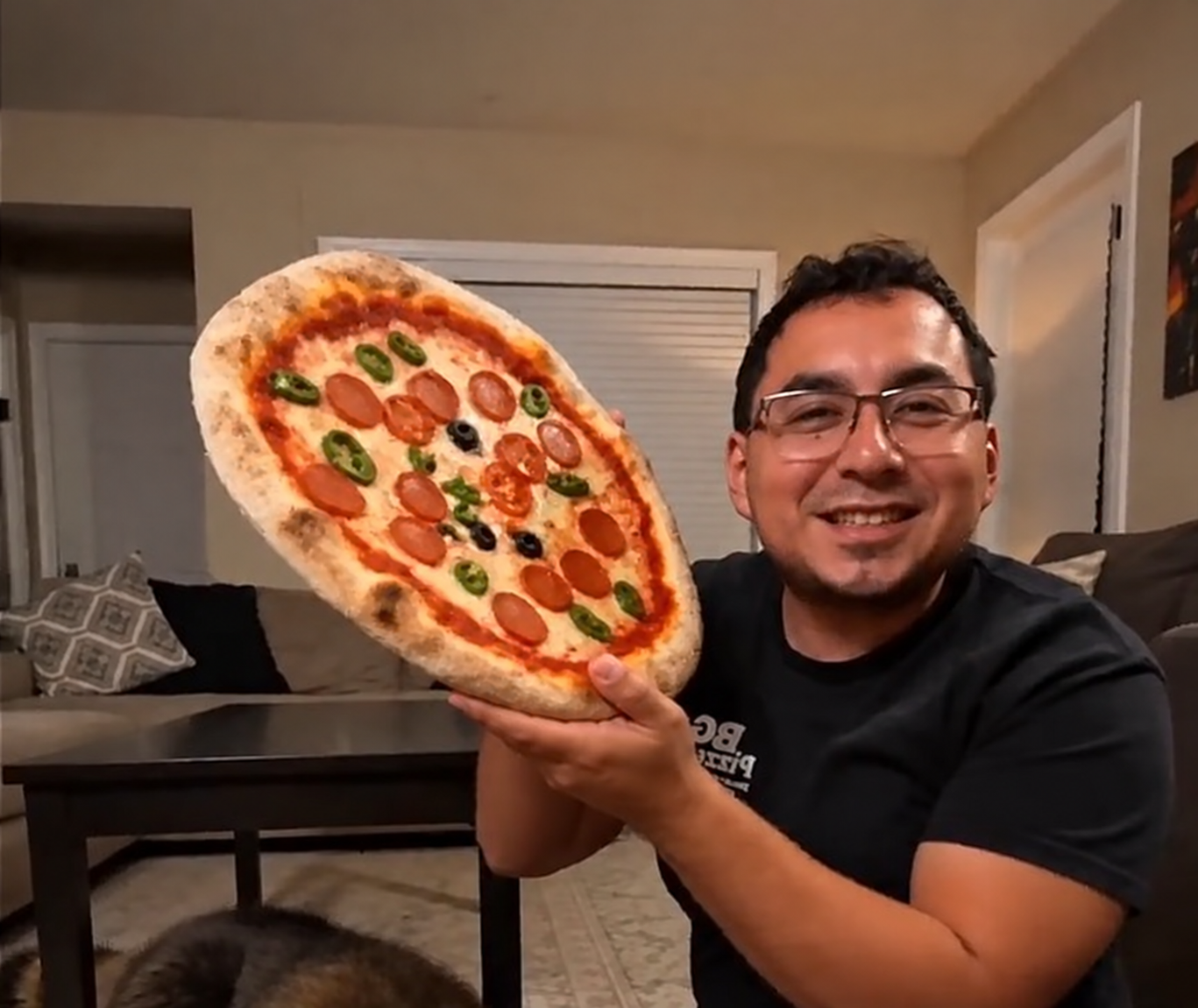 BG Pizzeria owner proudly showing a pizza